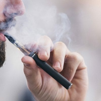 Person using e-cigarette Ashtons feature on MHRA guidance vaping